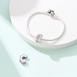 Detailed macro shot of silver snake chain bracelet with colorful floral enamel charms