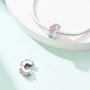 Macro detail of silver floral safety charm with colorful petals and zircon for bracelets