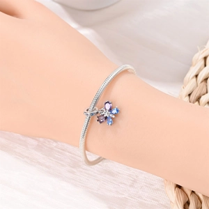 Macro view of silver snake chain bracelet with purple and blue gemstone butterfly charm
