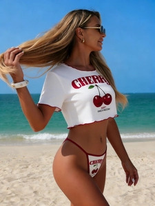 Detail of crop top with cherry print and matching bikini bottom on sunny beach