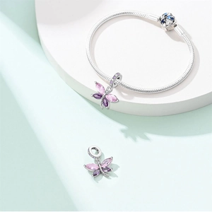 Detail of silver snake chain bracelet featuring a dragonfly charm with zircon wings