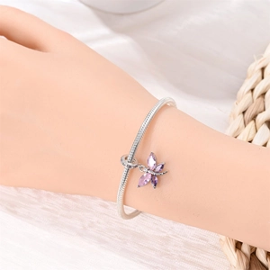 Silver snake chain bracelet featuring an elegant purple dragonfly charm on a wrist