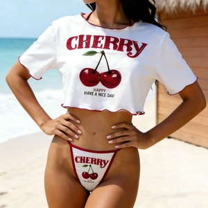 Slim fit white crop top T-shirt with cherry print and matching brief set on a beach