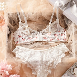 Close-up of white floral lace lingerie set with floral back band and golden metal hardware
