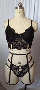 Détail d'un ensemble de lingerie sexy en dentelle noire avec porte-jarretelles et anneaux