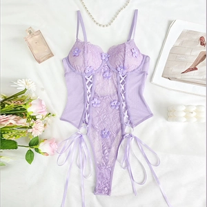 Detailed flat lay of purple lace bodysuit with floral appliques and lace-up ribbons