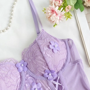 Detail of purple lace bodysuit with 3D floral appliqués and delicate pearl accents