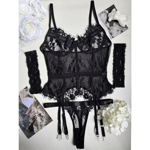 Detailed flat lay of black eyelash lace lingerie set with garters and matching sleeves