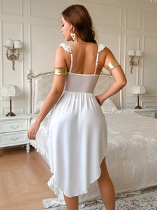 Détail de dos d'un ensemble de lingerie en satin blanc et tulle avec franges dorées