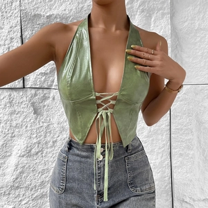 Detail of green faux leather halter top featuring deep V-neck and lace-up front closure