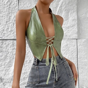 Detail of green faux leather halter top featuring lace-up front and textured finish