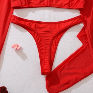 Flat lay of bright red mesh lingerie set with thong and sheer long sleeves on white