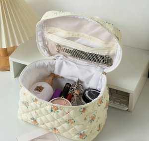 Interior detail of quilted floral makeup bag with dual mesh zipper pockets for storage