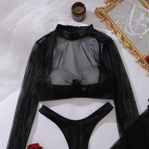 Flat lay of black sheer mesh lingerie set with long sleeves and lace details on white fabric