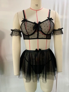 Detailed macro view of sheer black polka dot lace lingerie with silk bow accents