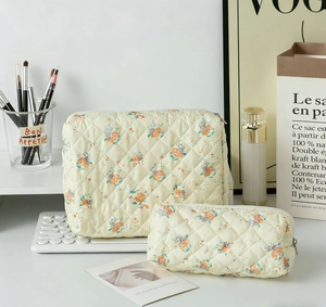 Macro detail of quilted floral makeup bags showing cotton texture and two-piece storage set