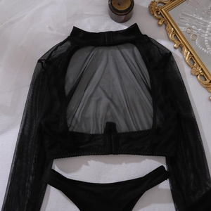 Flat lay of sheer black mesh lingerie set with back cut-out detail and luxury props