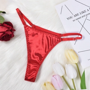Detail of red satin G-string featuring adjustable side straps on white plush background