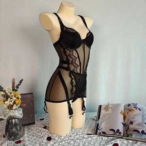 Detailed texture of black floral lace and sheer mesh on a boned corset bodysuit