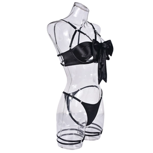 Detail of black lingerie set featuring oversized satin bow and crisscross straps