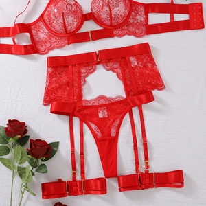 Detailed flat lay of red floral lace lingerie set with garters and golden buckles