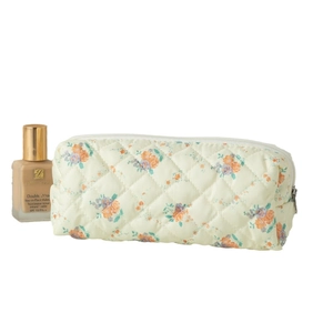 Quilted floral makeup bag in pale yellow with orange flowers and zipper closure