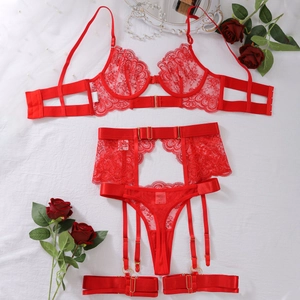 Flat lay of red lace lingerie set with floral embroidery, garter belt, and rose decor