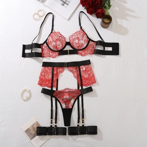 Detailed flat lay of red floral lace lingerie set with garters and gold hardware