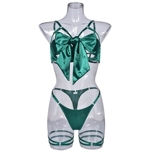 Close-up of emerald green satin lingerie set with large bow detail and thigh straps