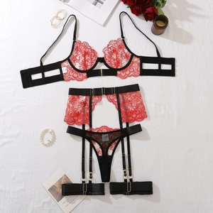 Detailed flat lay of red and black lace lingerie set with suspenders and garters
