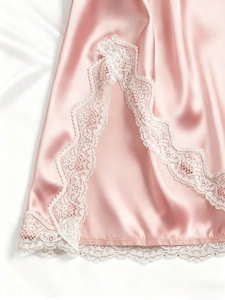 Detail view of pink satin lingerie featuring delicate white eyelash lace on the hem