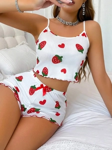 Dettaglio del pigiama bianco con stampa fragola e bordo a volant rosso sull'orlo