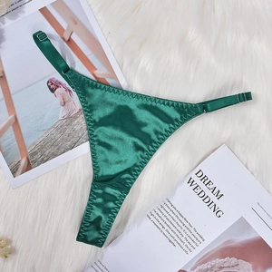 Detail of dark green satin thong with adjustable metal buckles on a plush background