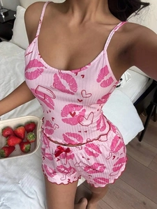 Dettaglio del completo rosa con stampe labbra rosse, cuori e bordi a onde con fiocchetto