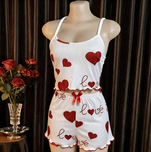 Dettaglio del pigiama bianco in maglia a costine con cuori rossi e scritta “Love”