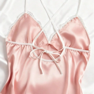 Pink satin nightgown with white lace trim and criss-cross straps for a silky luxury look
