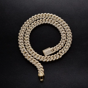 Macro detail of 10mm gold Cuban link chain with micro-pave zircons and iced-out box clasp
