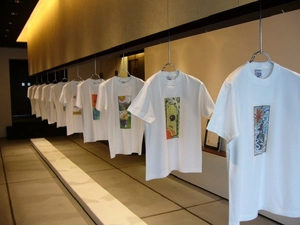 Close-up of white crew neck T-shirts with colorful prints hanging in a fashion showroom