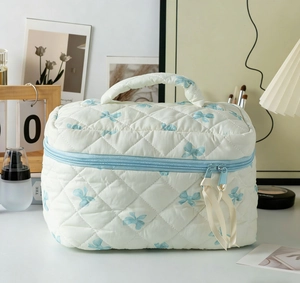 Gesteppte Kosmetiktasche mit Schmetterlingsdruck und Tragegriff im Wohnambiente