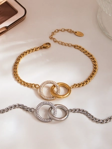 Detail von ineinandergreifenden Doppelring-Armbändern in Gold und Silber mit Zirkon