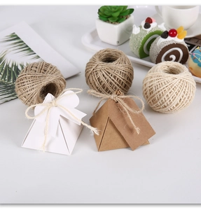 Macro view of natural jute twine balls and vintage pyramid kraft paper gift boxes with tags