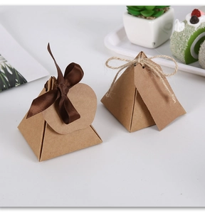 Close-up of pyramid kraft paper gift boxes with brown ribbon and rustic hemp rope ties