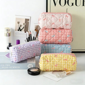 Detail of five colored quilted cosmetic bags with bow embroidery and zipper closure