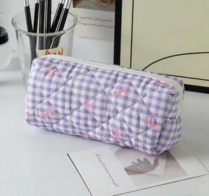 Detailed view of purple gingham quilted pencil case with soft pink ribbon patterns