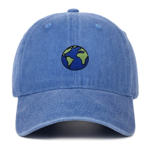 Close-up of earth embroidery on light blue washed cotton baseball cap with fine stitching