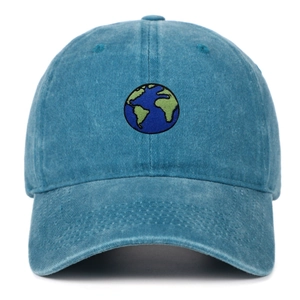 Close-up of earth embroidery on washed blue cotton baseball cap with vintage texture