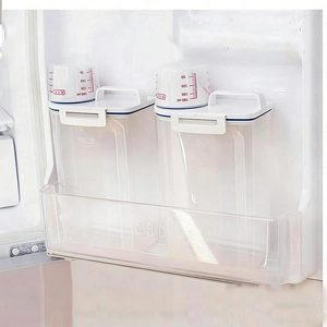 Set of 2 clear plastic cereal storage containers with white lids in refrigerator