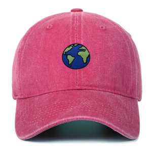 Close-up of earth embroidery on rose pink washed cotton baseball cap with vintage texture