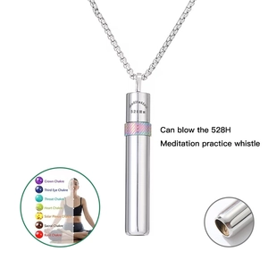 Dettaglio macro della collana a fischietto per meditazione 528Hz in acciaio con anello colorato