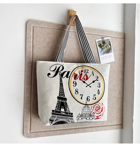 Detail of canvas tote bag with Eiffel Tower print and black-white striped strap